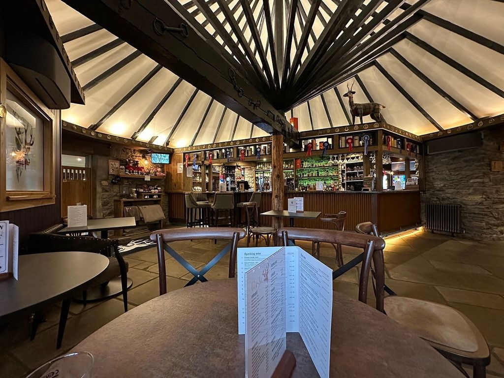 Wooden pub tables laid with cutlery and candles ready for evening service in the bar